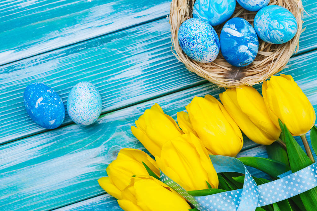 Uova di Pasqua e tulipani. Decorazione festiva su sfondo in legno. Biglietto vacanza con spazio per la copia - Foto, immagini
