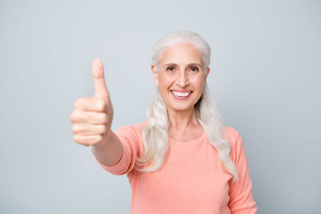Close-up foto retrato de encantador senhora avó fazendo dedo para cima sinal vestindo cor de pêssego pulôver isolado fundo cinza
 - Foto, Imagem