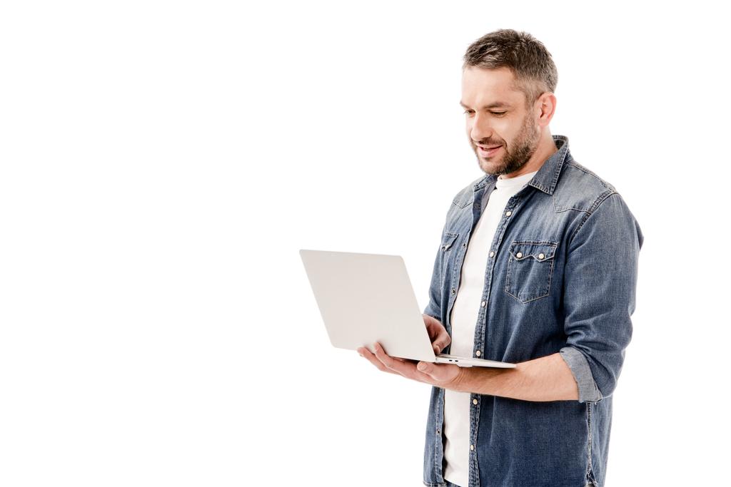 homem sorridente em camisa jeans usando laptop isolado em branco
 - Foto, Imagem