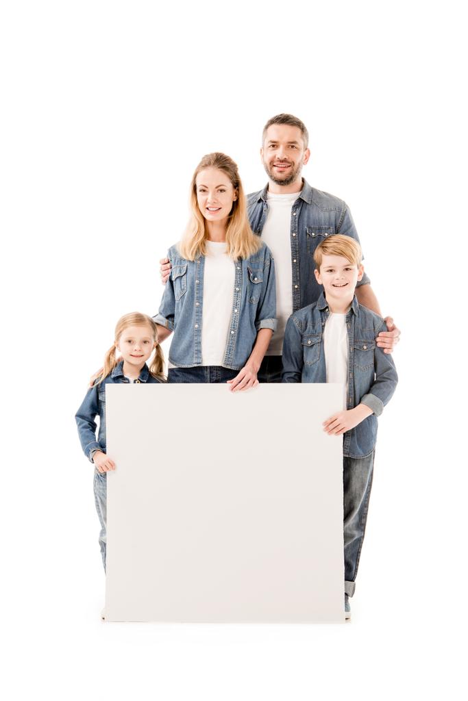 volledige lengte weergave van gelukkige familie glimlachend en holding blanco plakkaat geïsoleerd op wit - Foto, afbeelding