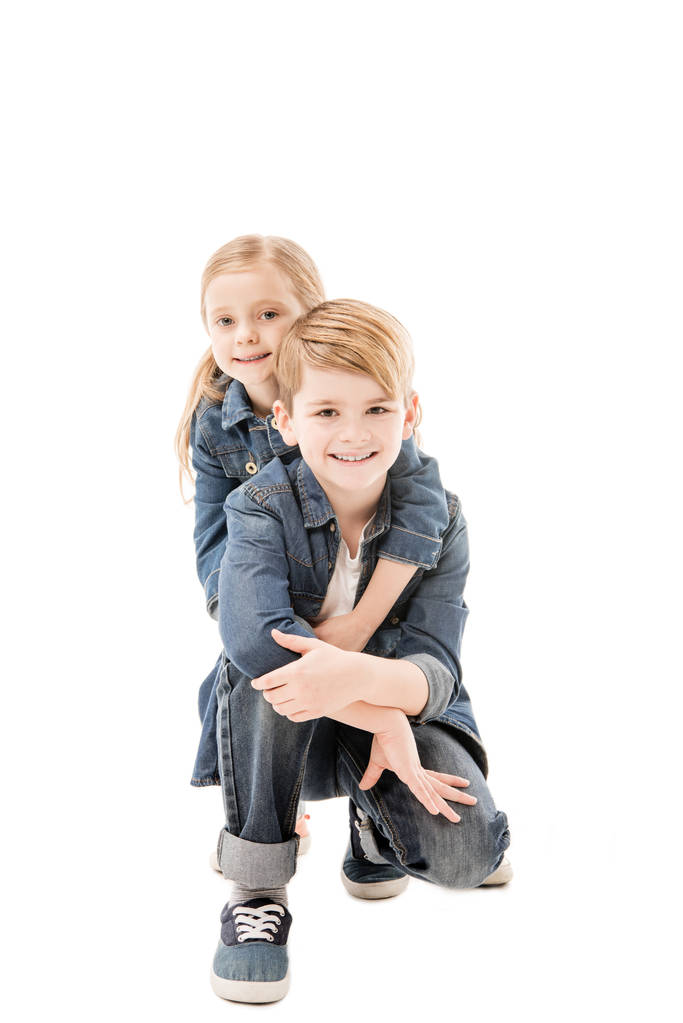 glückliche Kinder, die sich umarmen und vereinzelt in die Kamera schauen - Foto, Bild