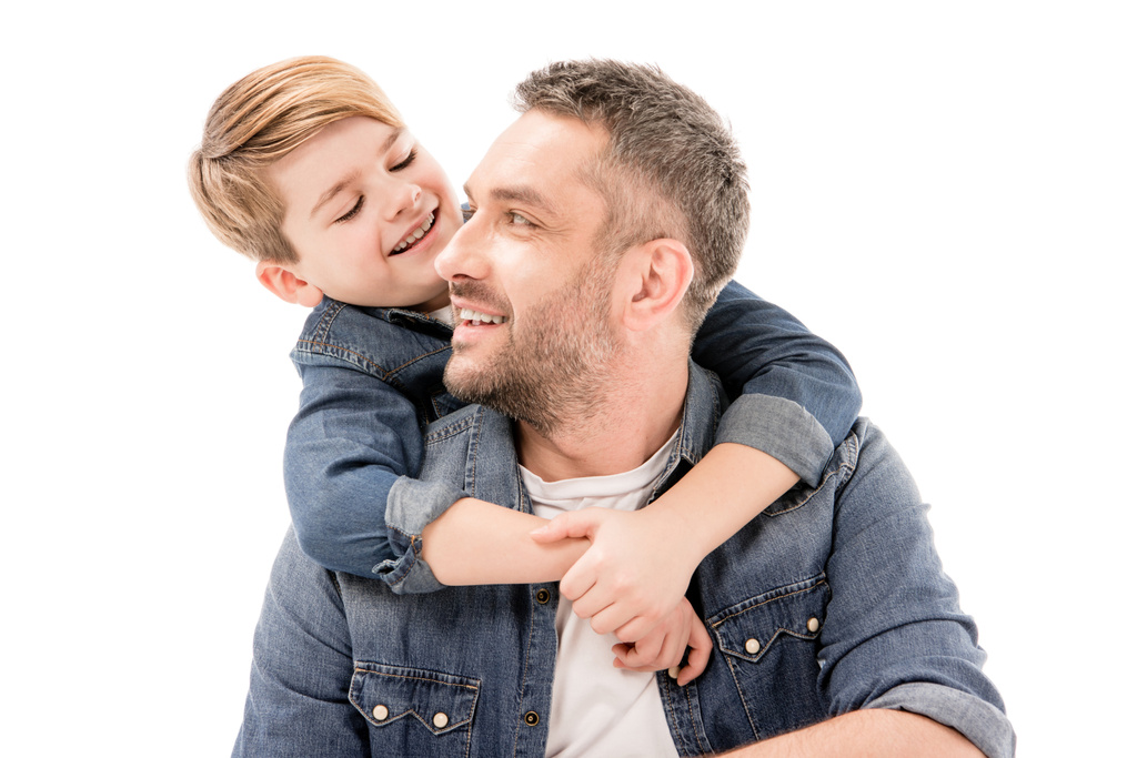 opgewonden lachende jongen omarmt vader geïsoleerd op wit - Foto, afbeelding