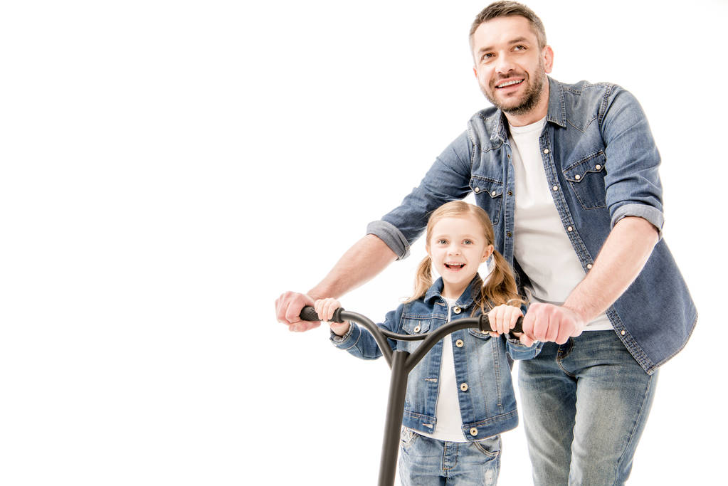 lachende vader en dochter met scooter geïsoleerd op wit - Foto, afbeelding