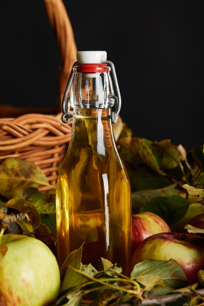 garrafa de cidra perto de cesta de vime e maçãs na superfície de madeira
 - Foto, Imagem