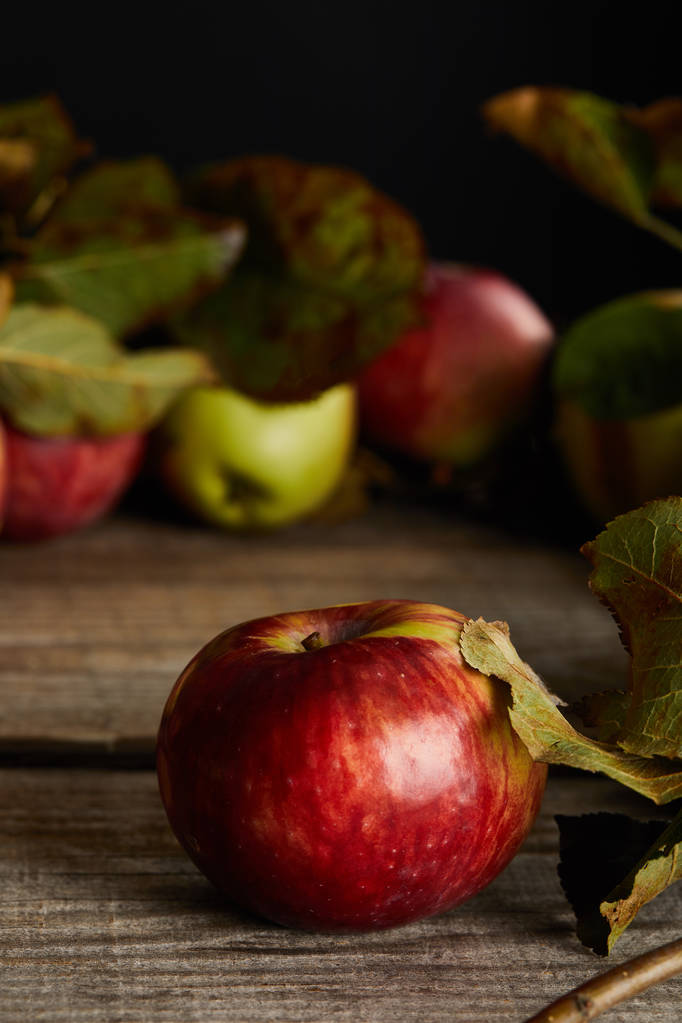 Vörös érett alma levelekkel, fafelületre izolált fekete - Fotó, kép