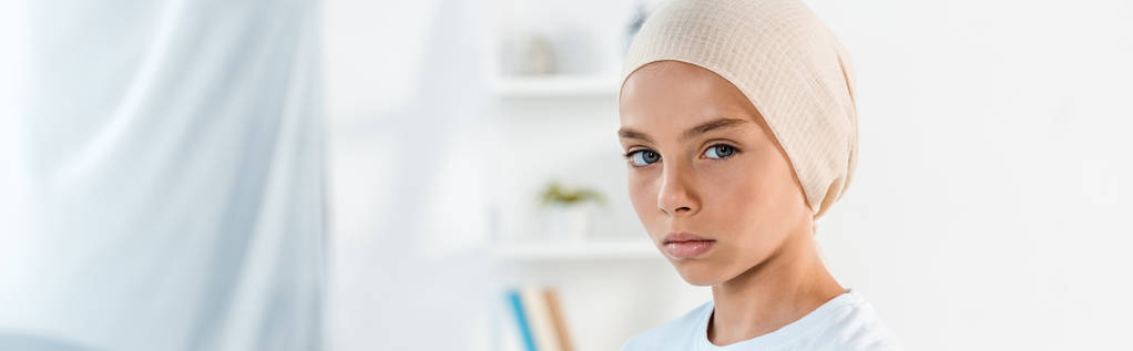πανοραμική βολή του άρρωστου παιδιού στο κεφάλι κασκόλ κοιτάζοντας την κάμερα - Φωτογραφία, εικόνα
