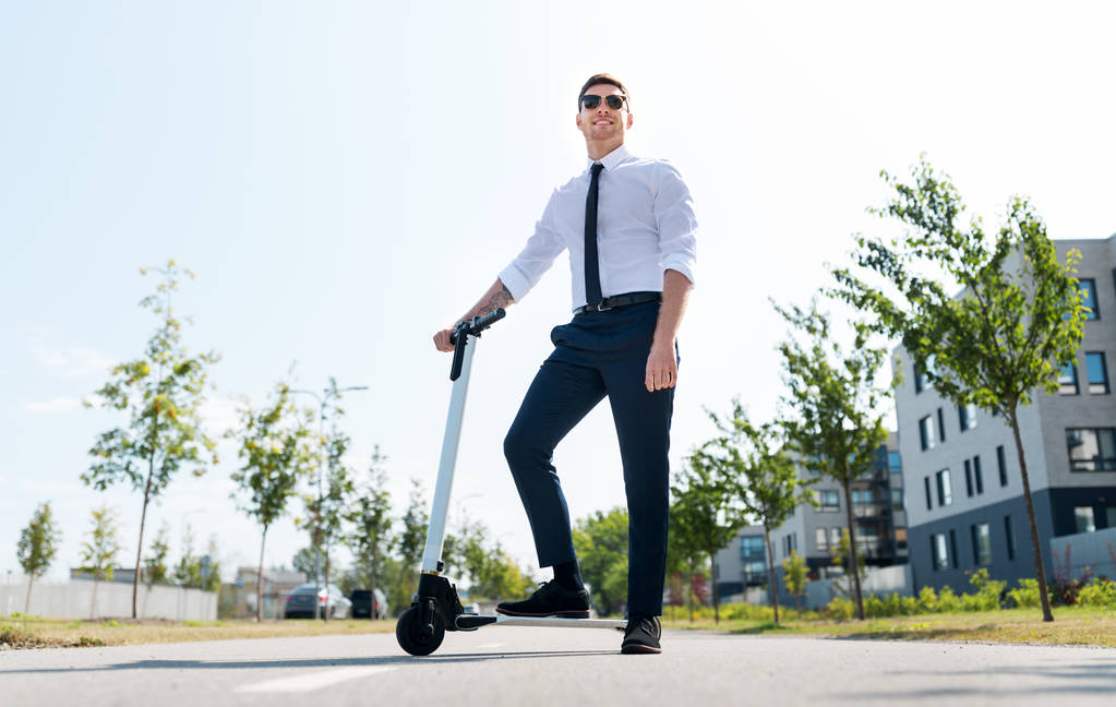 jovem empresário montando scooter elétrico ao ar livre - Foto, Imagem