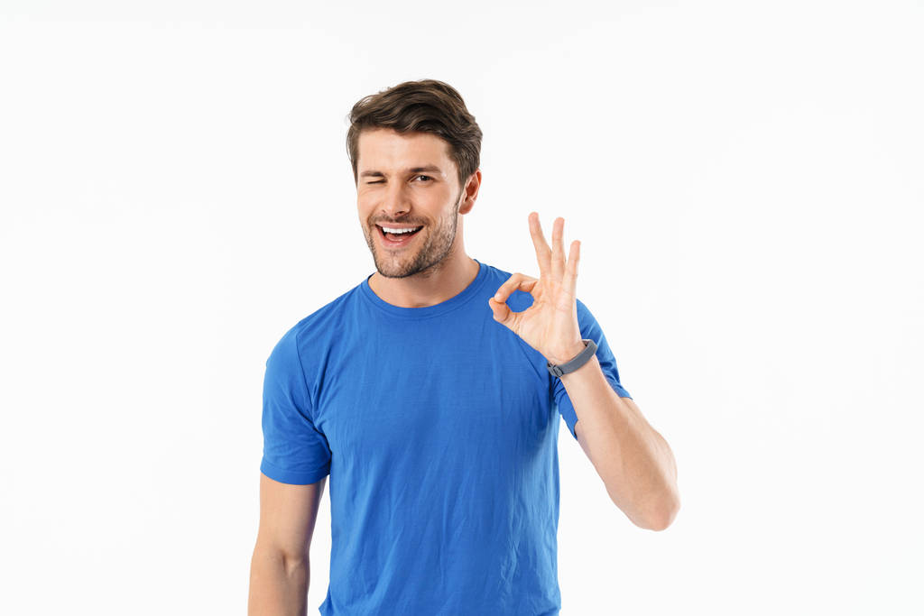 Aantrekkelijke jonge fit sportman dragen t-shirt staande - Foto, afbeelding