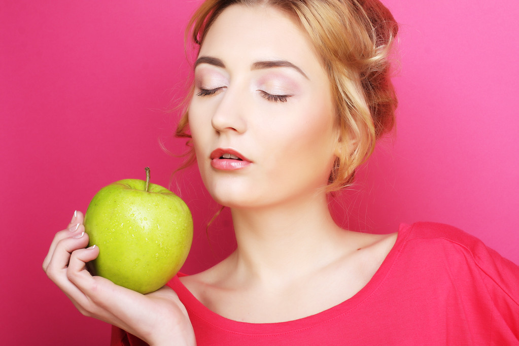 Жінка з яблуком над рожевим тлом
 - Фото, зображення