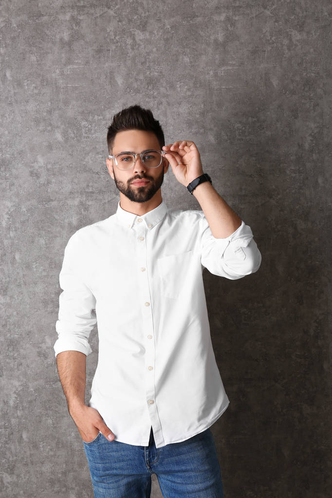 Porträt eines gutaussehenden Mannes mit Brille auf grauem Hintergrund - Foto, Bild