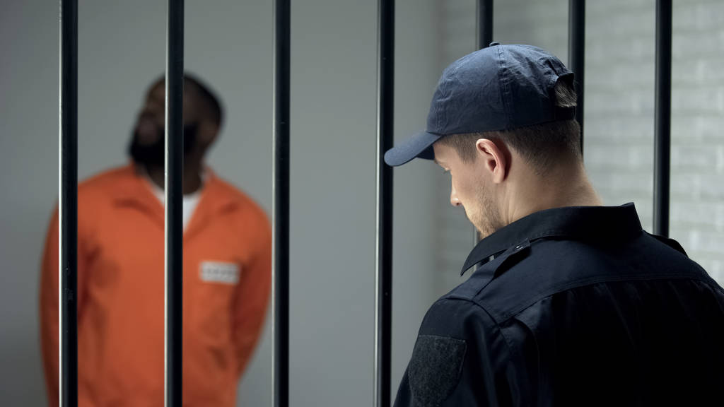 Φρουρός ασφαλείας φυλακών που φροντίζει επικίνδυνους εγκληματίες στο κελί, 24 ώρες φύλαξη - Φωτογραφία, εικόνα