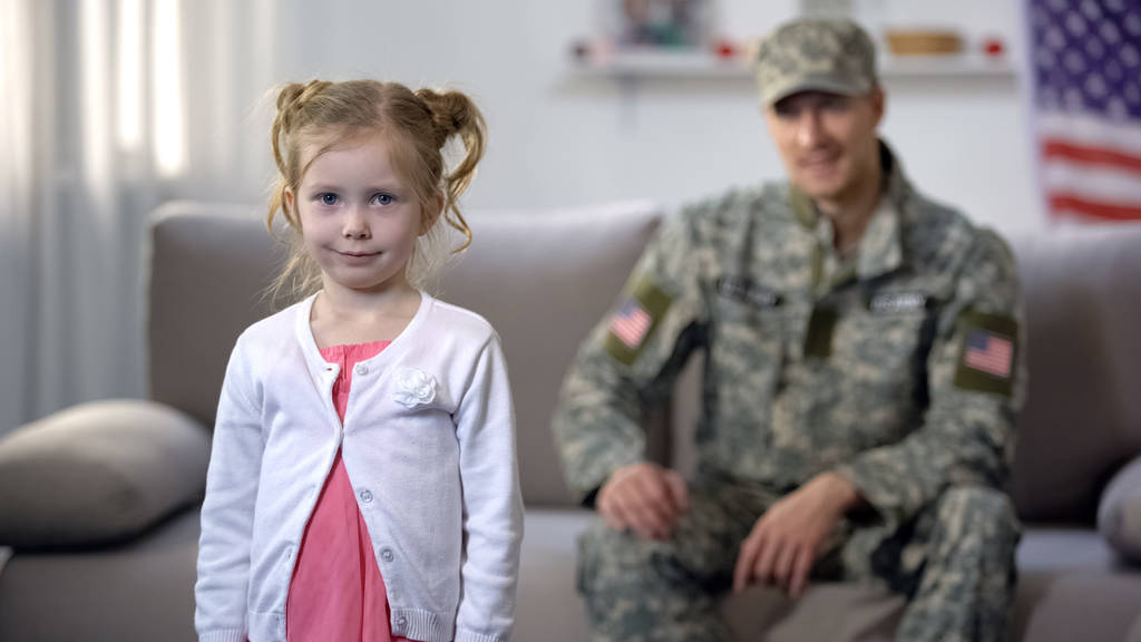 Veselý americký voják otec obdivuje roztomilou dceru, jak se dívá na kameru, hrdost - Fotografie, Obrázek