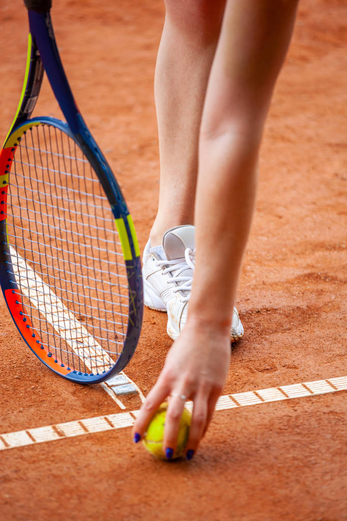Jugadora de tenis piernas en zapatillas de tenis de pie en un cou de arcilla
 - Foto, Imagen