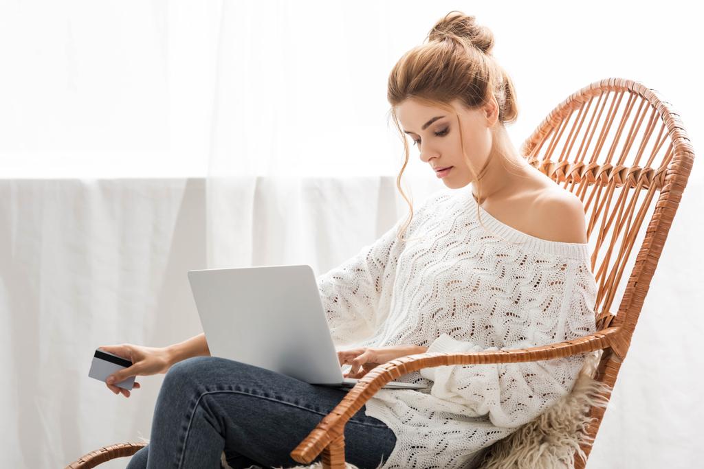 attraente donna in maglione bianco in possesso di credito e laptop
 - Foto, immagini