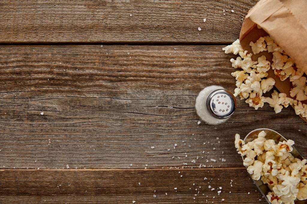 вид вкусного попкорна с солью на деревянном фоне
 - Фото, изображение