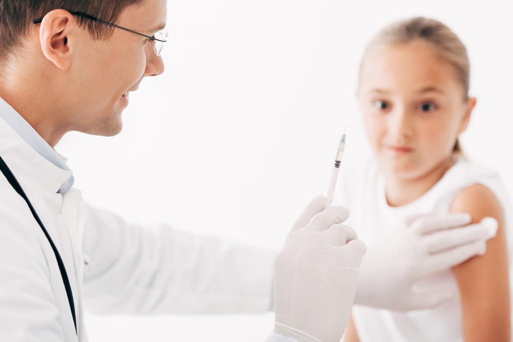 Teilansicht des Kinderarztes, der dem Kind eine Spritze verabreicht, isoliert auf Weiß - Foto, Bild