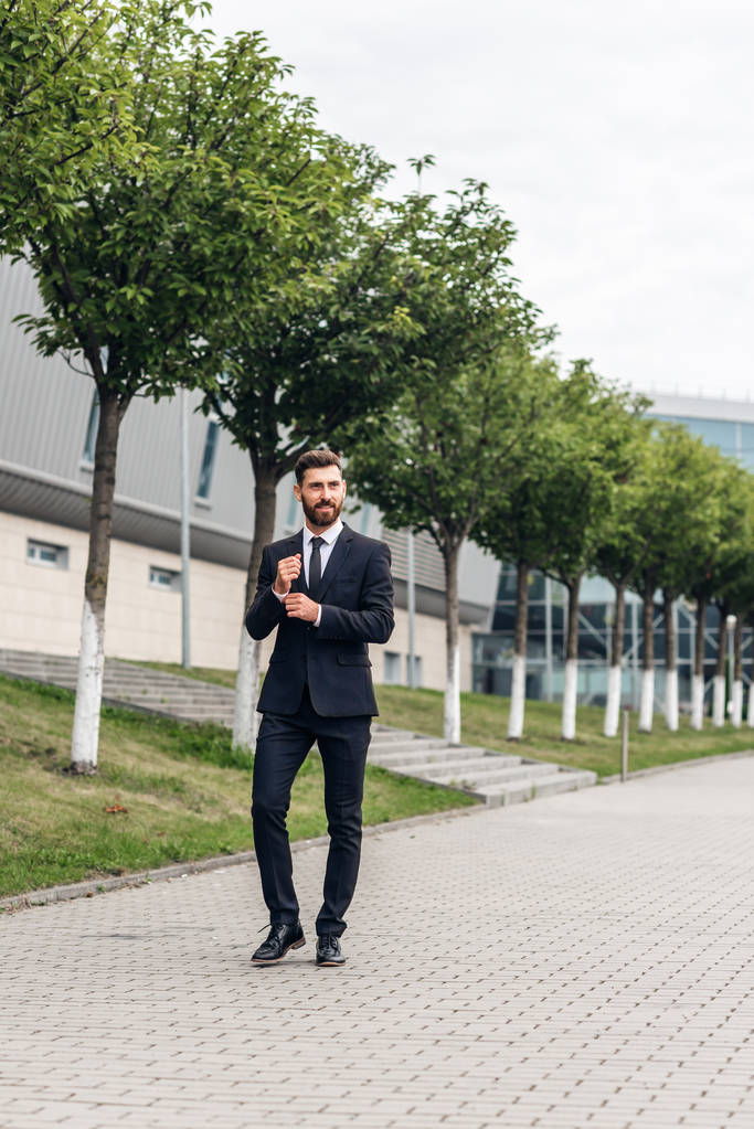 Empresário em um terno caro e sapatos vai para a praça, finanças e startups
 - Foto, Imagem