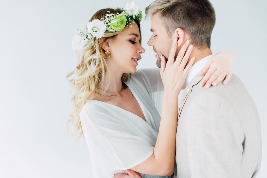 attraktive Braut und schöner Bräutigam umarmen und küssen sich mit geschlossenen Augen - Foto, Bild
