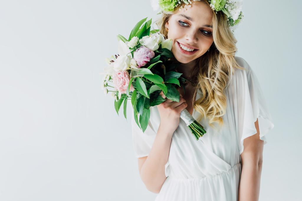 jolie mariée en robe de mariée et couronne tenant bouquet isolé sur blanc
 - Photo, image