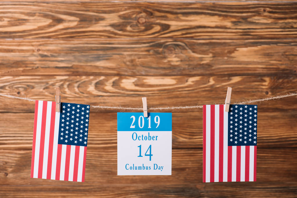 木製の表面上のアメリカの国旗の間の10月14日の日付とカレンダー - 写真・画像