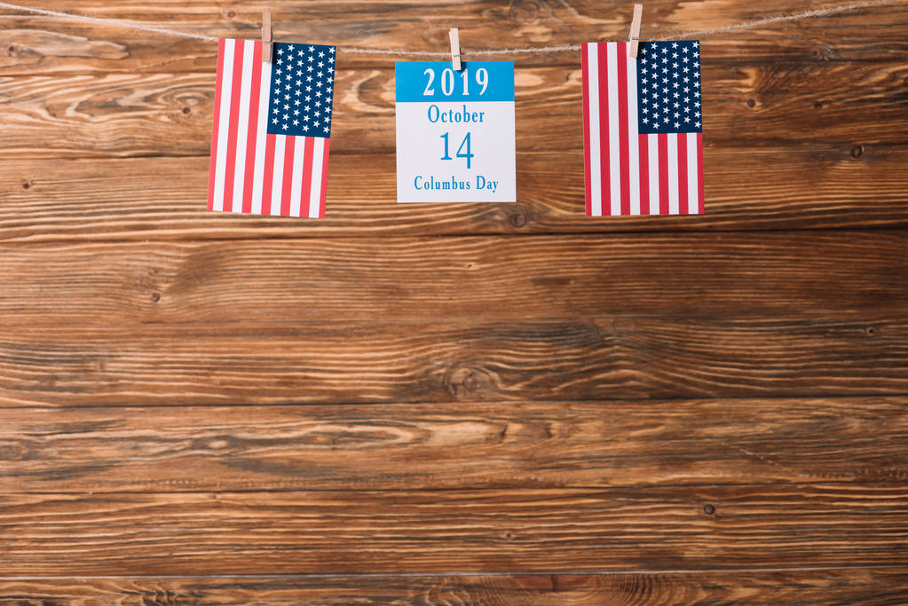 calendario con fecha 14 de octubre entre banderas nacionales americanas sobre superficie de madera
 - Foto, imagen