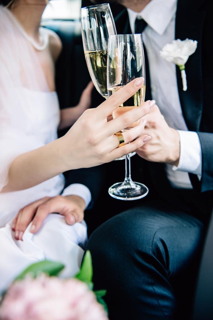 Ausgeschnittene Ansicht von Braut und Bräutigam, die mit Champagnergläsern klirren - Foto, Bild