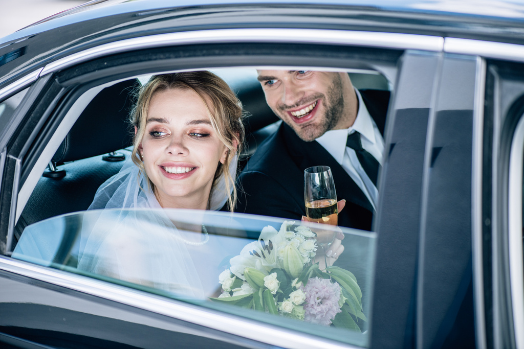 ελκυστική νύφη και όμορφος γαμπρός κουδουνιά με ποτήρια σαμπάνιας - Φωτογραφία, εικόνα