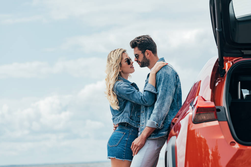 привлекательная женщина и красивый мужчина в джинсовых куртках обнимаются снаружи
  - Фото, изображение