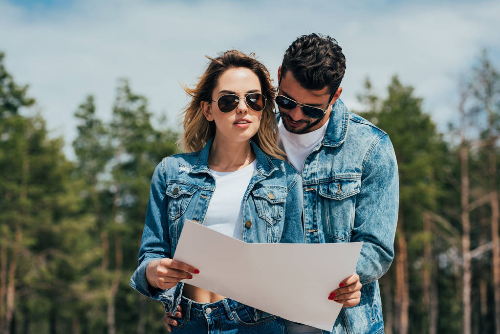 attractive woman and handsome man in jackets looking at map - Photo, Image