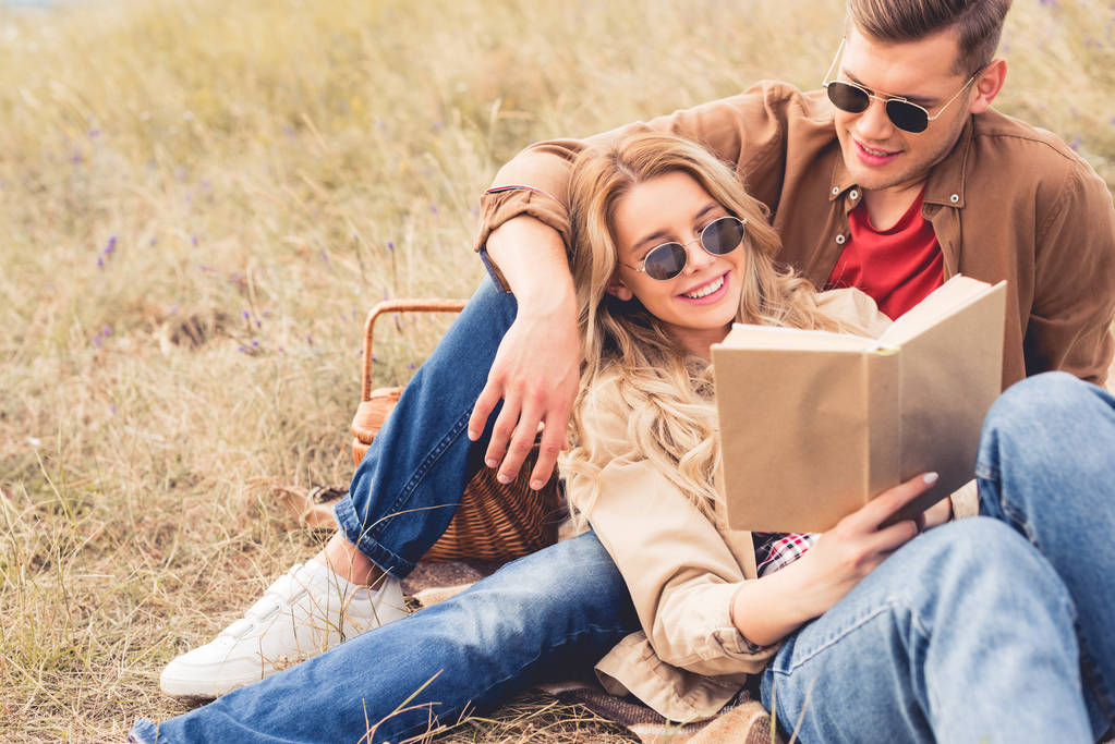 привлекательная женщина и красивый мужчина улыбается и читает книгу
  - Фото, изображение