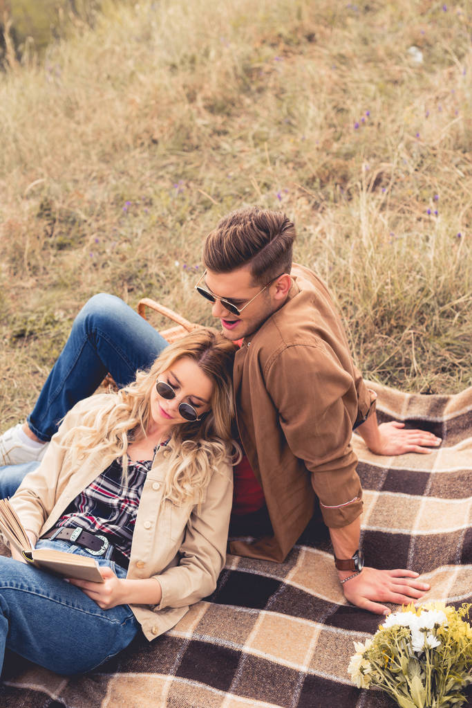 attractive woman and handsome man in sunglasses reading book  - Photo, Image