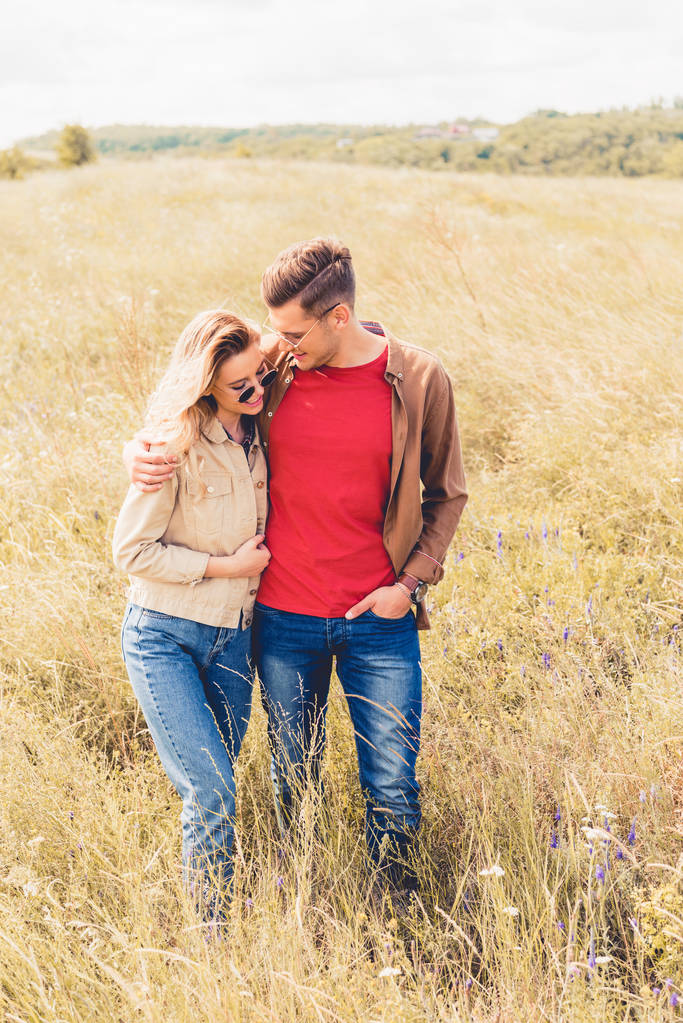 attractive woman and handsome man in sunglasses hugging outside  - Photo, Image