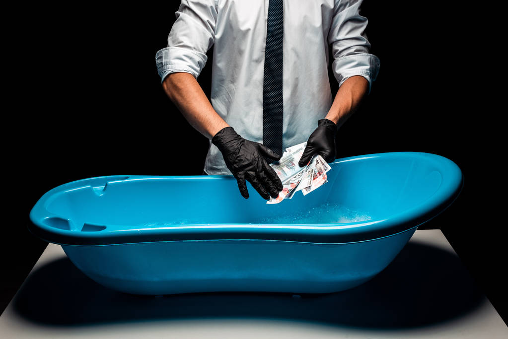 vista ritagliata dell'uomo in giacca e cravatta con soldi russi vicino al bacino di plastica blu su nero
  - Foto, immagini