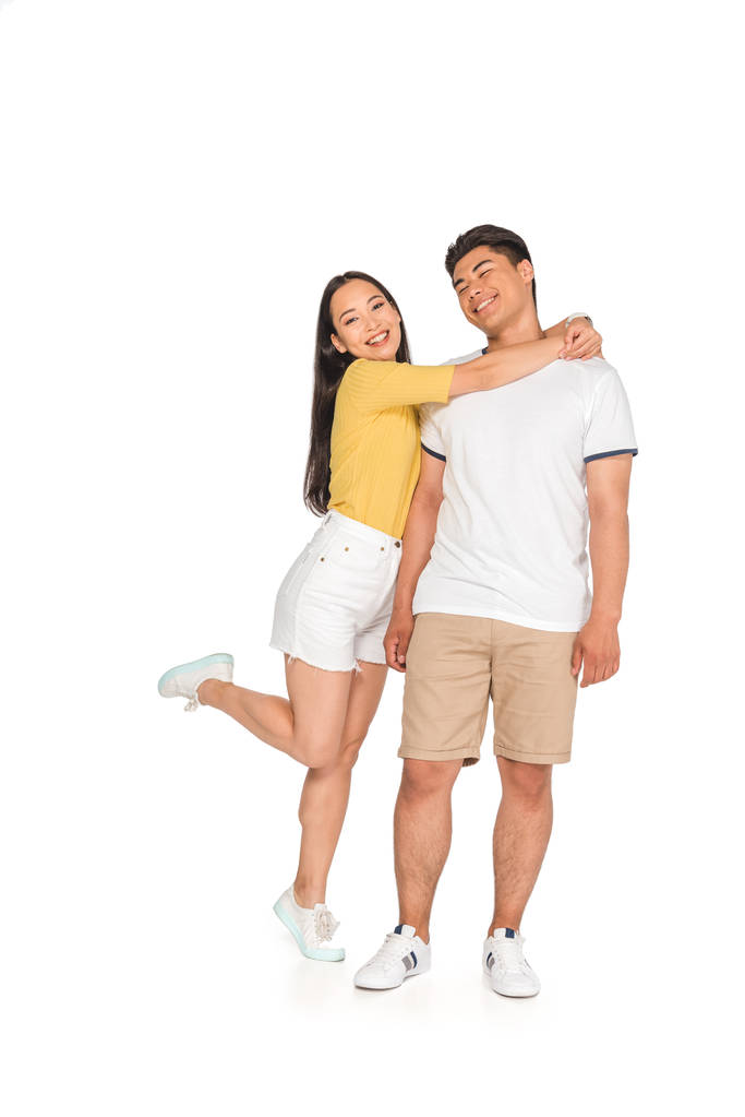 happy asian girl embracing handsome boyfriend on white background - Photo, Image