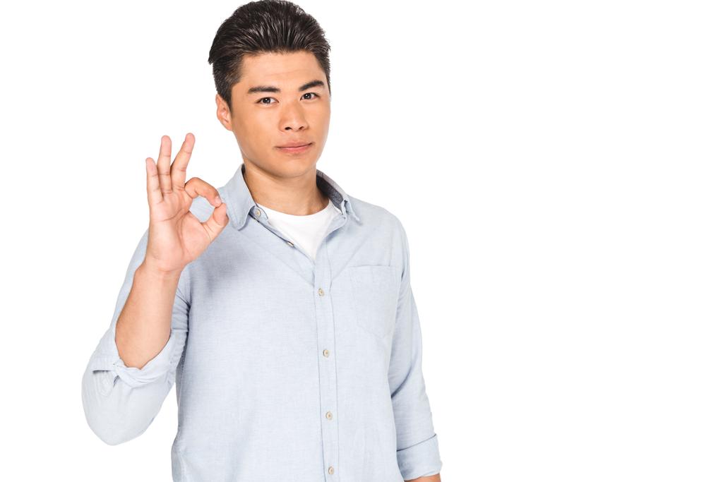 jovem asiático homem mostrando ok sinal enquanto olhando para câmera isolado no branco
 - Foto, Imagem