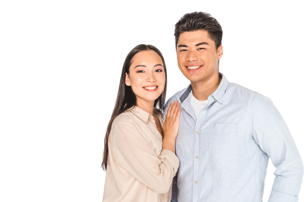 glücklich asiatische Frau umarmt schönen Freund, während lächelnd in die Kamera isoliert auf weiß - Foto, Bild