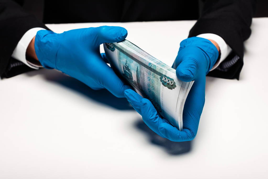 visão cortada do homem em luvas de látex segurando dinheiro russo em branco
  - Foto, Imagem