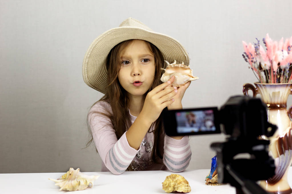 Het kind voor de camera toont de schelpen - Foto, afbeelding