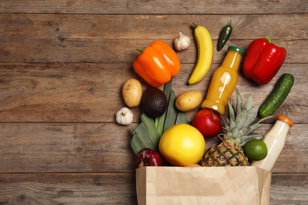 Nákupní taška s různými potravinami na dřevěném podkladu, plochá. Místo pro text - Fotografie, Obrázek