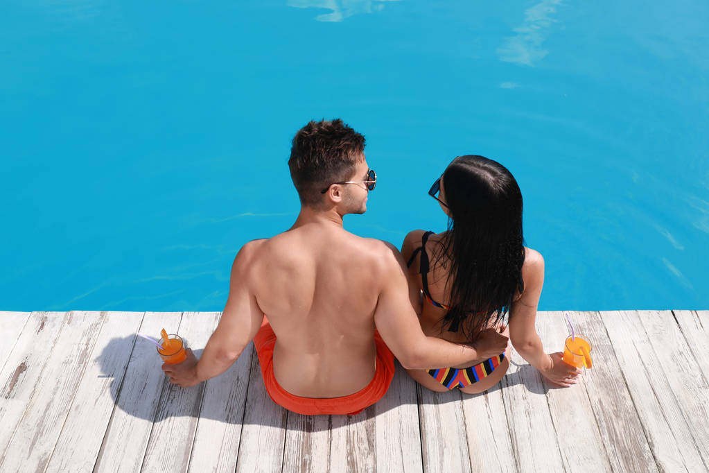 屋外プールの近くにボーイフレンドとビキニの女性。若いカップル - 写真・画像