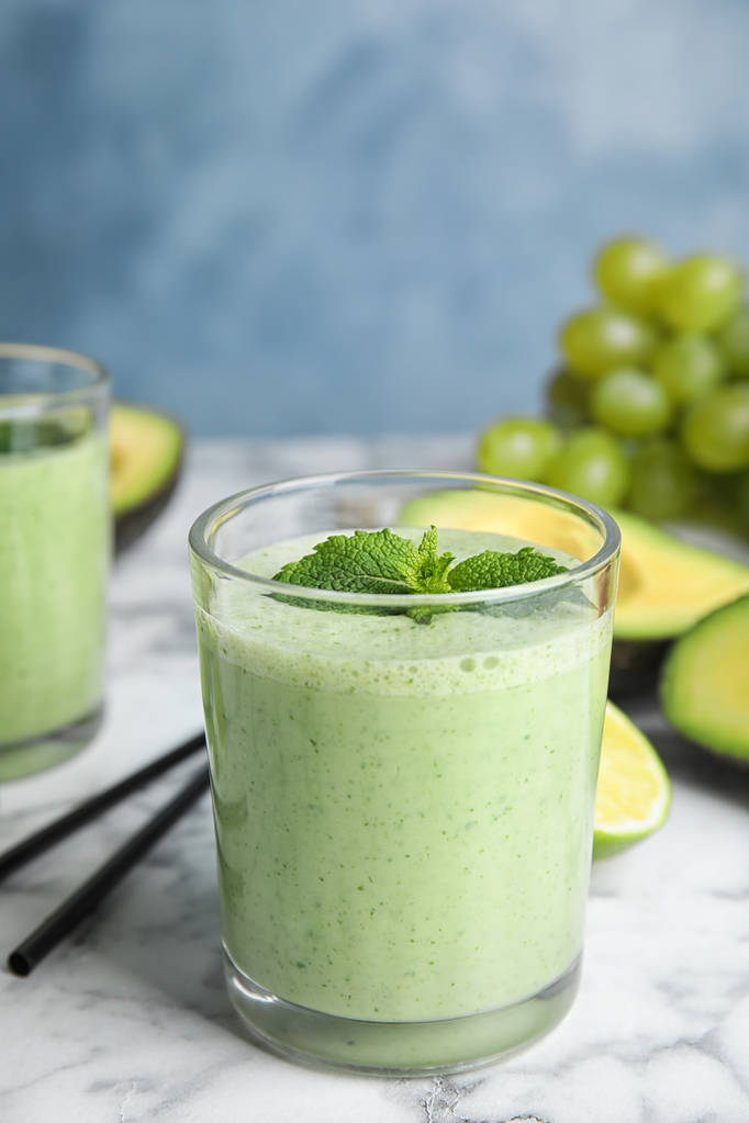 Glass of tasty avocado smoothie with mint on marble table - Photo, Image