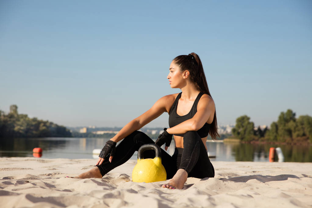 Jovem atleta feminina saudável fazendo exercício na praia
 - Foto, Imagem