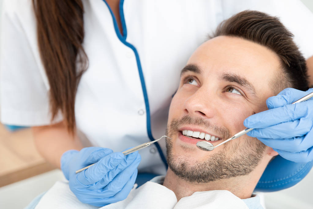 歯科医で歯を調べてを持つ男 - 写真・画像