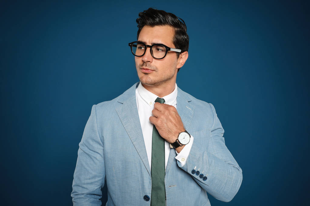 Portret przystojnego młodego biznesmena noszący okulary na niebieskim tle - Zdjęcie, obraz