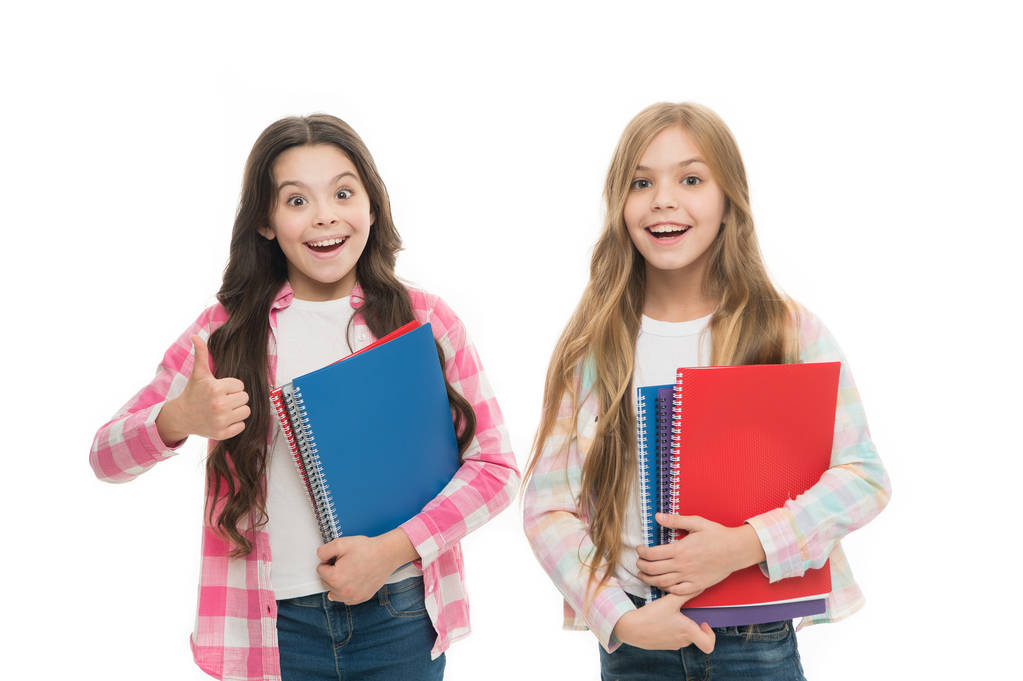 Recommending the books. Small girls giving thumbs up for school activity books. Little children enjoy writing in their note books. Exercise books taking children through the school term comfortably - Photo, Image