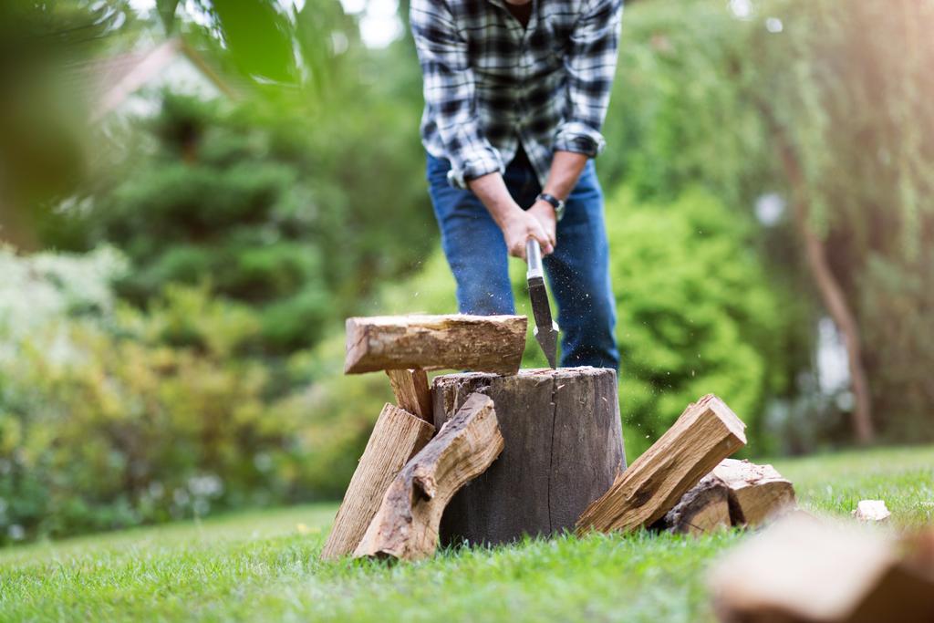 Hombre mayor cortando troncos, trabajando en el jardín (enfoque en hacha
) - Foto, Imagen