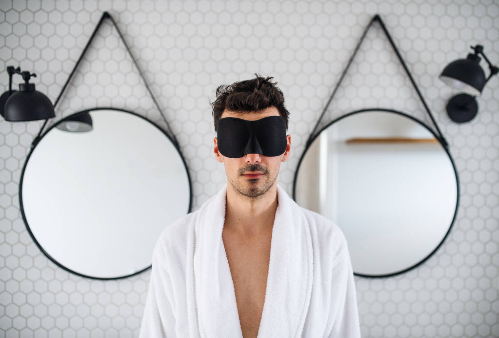 Young man with eye mask in the bathroom in the morning. - Photo, Image