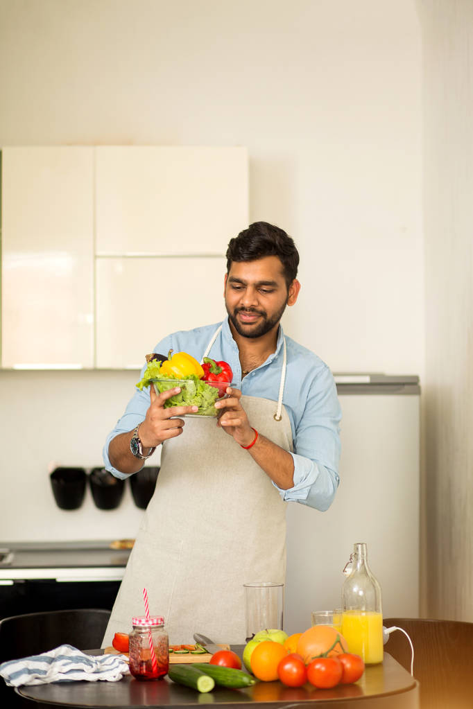 Όμορφος νέος άντρας στέκεται στην κουζίνα στο σπίτι - Φωτογραφία, εικόνα