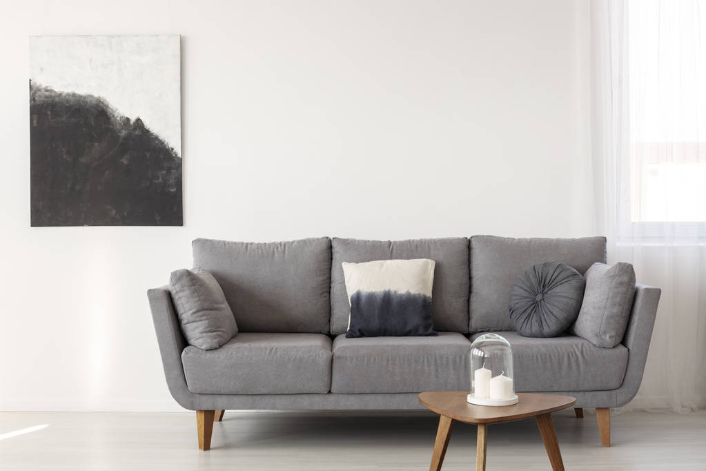 Серый скандинавский диван в светлом интерьере гостиной
 - Фото, изображение