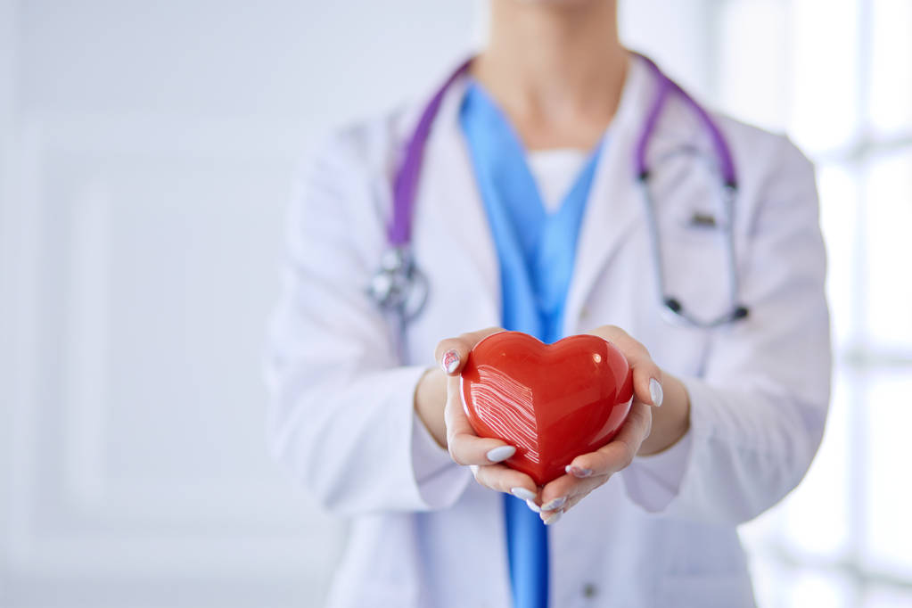 Lekarz ze stetoskopem trzymającym serce, odizolowany na białym tle - Zdjęcie, obraz